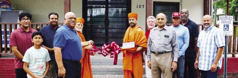 Store owner Neil Patel (third from left) was joined by Eatonton Mayor John Reid (blue shirt), two “saints” from BAPS Mandir, and Eatonton-Putnam Chamber of Commerce CEO Robbie King (red shirt), among others, for a Memorial Day ribbon cutting at Stop N Go, on Eatonton’s Martin Luther King Jr. Drive. IAN TOCHER/Staff