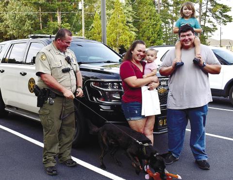 Posing with K9 “Storm,” are Deputy Alex Rickey, Shelby Flores with baby Mateo Flores, and Alfred Flores with daughter Lucy Flores.