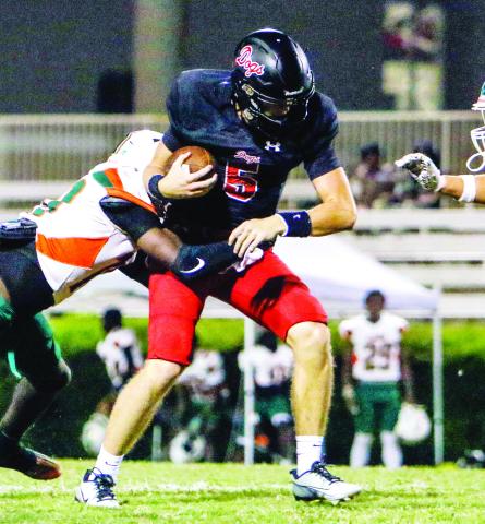 Morgan County quarterback Davis Strickland (5) tries to shrug off a Rutland defender and pick up some positive yardage. LANCE McCURLEY/Staff