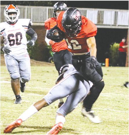 Morgan County senior wide receiver Reggie Ross (12) tries to hurdle a defender after hauling in a pass from quarterback Talan Fuller. LANCE McCURLEY/Staff