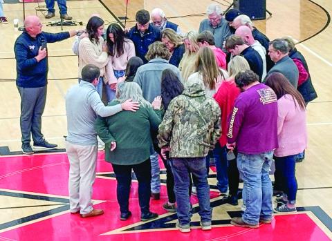 The families of Bennett Rabern, Avett Jackson, and Bryson Hammond are prayed over at a community vigil held Sunday at Morgan County High School. HANNAH BARRON/Staff