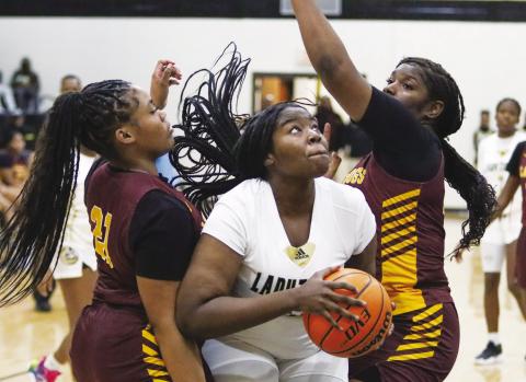 Kayla Sigman tries to go up and over two Hancock Central defenders during a game last season. She’s been huge for Greene County this season on the boards. LANCE McCURLEY/Staff