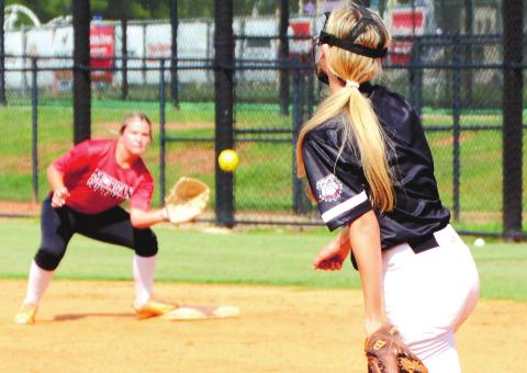 Emmy Moss (right) fires a laser to Bri Lanford (left) during an infield drill at Tuesday’s practice. BRENDAN KOERNER/Staff