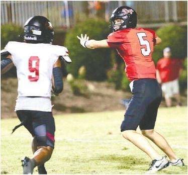 Bulldogs’ quarterback Davis Strickland (5) gets set to let the ball loose while being chased down by a Hebron Christian defender (9). JIM TURNER/Contributed