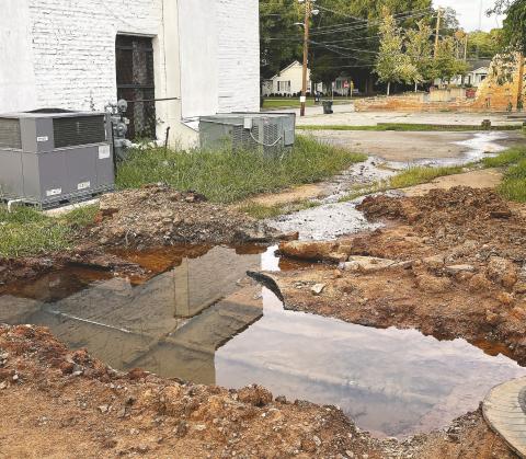 Leaking pipes create runoff behind a downtown property, spilling into the foundation MAUREEN STRATTON/Staff