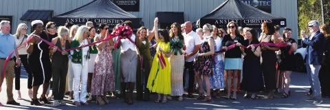 Adriana Velez (center with scissors) was joined by a large throng of business colleagues and well wishers last Thursday as she officially cut the ribbon to her new Ansley R.E.-Christie’s Int’l. business center in a joint ceremony co-hosted by Eatonton-Putnam Chamber of Commerce President Robbie King and Greene County Chamber of Commerce President Mika Mills (both, far right). IAN TOCHER/Staff