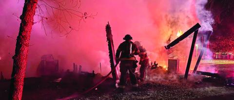 Putnam County Fire Department firefighters extinguish what was left of a fire that burned this detached garage to the ground last week. CONTRIBUTED