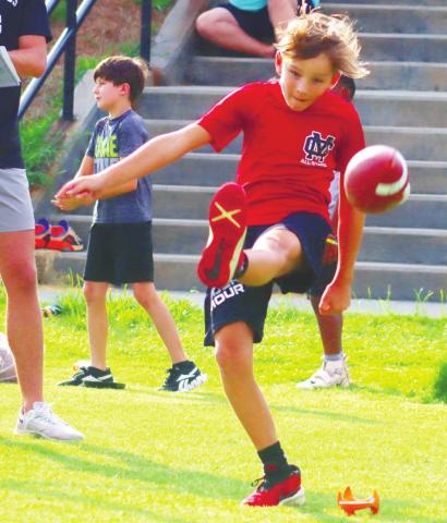 A camper sends a punt orbiting off his right foot, which ended up going 25-yards. LANCE McCURLEY/Staff
