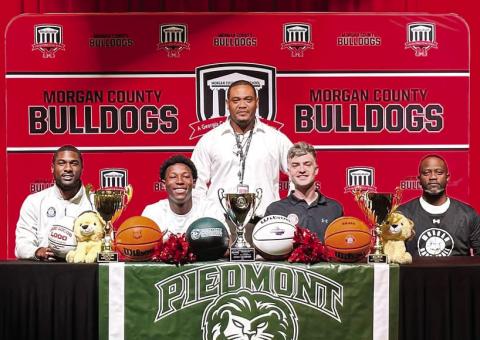 Morgan County senior Zeki Locus (second from left, front row) poses with his coaches after signing with Piedmont University to continue his basketball career. CONTRIBUTED