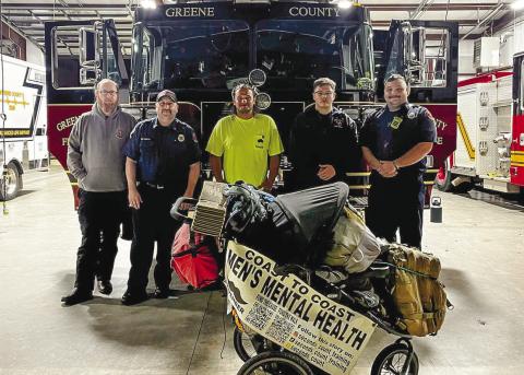 Dalton Mack (center) takes a break from his long walk across America to raise awareness for men’s mental health and spends time with Greene County firefighters. CONTRIBUTED