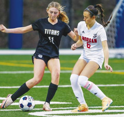LOA sophomore Addi Everett (11) tries to dribble the ball past Morgan County’s Molly Mockaitis (6) in a 5-0 loss to the Lady Dogs on Feb. 10. LANCE McCURLEY/Staff