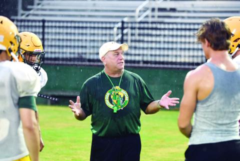 With rain soaking everyone’s shirts and jerseys, Gatewood head coach Jeff Ratliff explains his next drill during practice last Friday at Sammons Field in Eatonton. IAN TOCHER/Staff