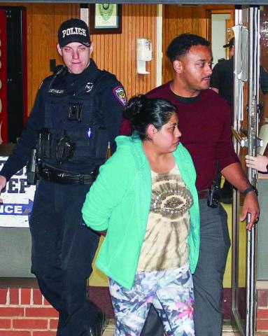 Reyna Lopez, front center, is escorted by Eatonton Police Department officers Chris Detweiler (left) and investigator Hargrove Jones, who are taking Lopez to jail at Putnam County Sheriff’s Office. CONTRIBUTED/EPD