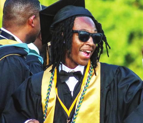 A Greene County class of 2022 graduate smiles as he walks across the stage after receiving his diploma. LANCE McCURLEY/Staff
