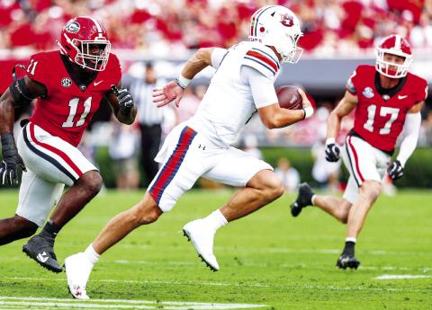 Georgia linebacker Jalon Walker (11) and defensive back Dan Jackson (17) chase down Auburn quarterback Peyton Thorne. COURTESY OF UGA ATHLETICS