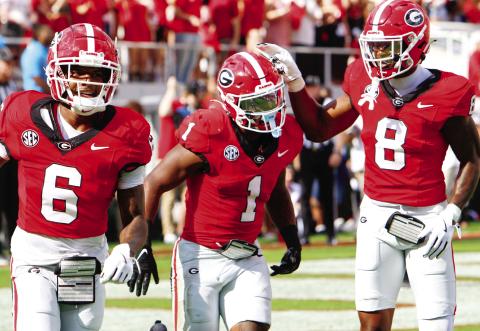 Georgia wide receiver Dominic Lovett (6), running back Trevor Etiennte (1) and wide receiver Colbie Young during Saturday’s win. LANCE McCURLEY/Staff