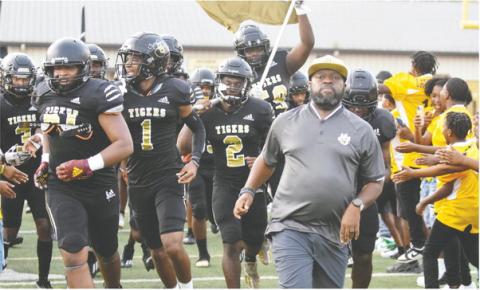 Greene County head coach Terrance Banks leads his team out onto the field in one of the Tigers’ first games of the field. BRENDAN KOERNER/Staff