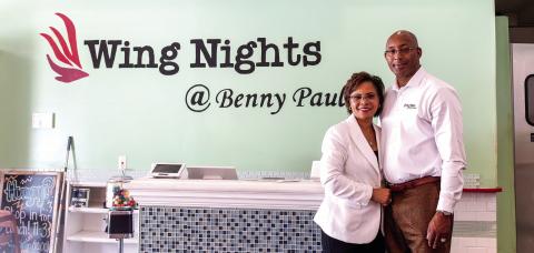 Brince and Emily Benford, owners of Wing Nights at Benny Paul’s, pose inside their restaurant in downtown Madison. The husband-and-wife team opened the business seven years ago and will celebrate five years at their current location in 2027. SKYLA MORRIS/Staff