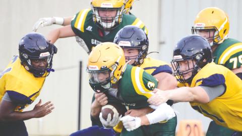 Junior running back Jackson Hewatt (3) is the center of attention for teammates and rivals alike in a first-quarter scrimmage run Friday night at Gatewood Schools in Eatonton, versus the Cavaliers of Mount de Sales Academy. IAN TOCHER/Staff