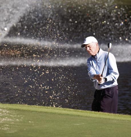 Doug Denholm hits a shot out of the bunker onto the green. LEIGH LOFGREN/Staff