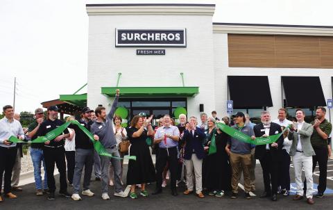 Kyle Cullars (center, holding scissors) completes the ribbon cutting for Surcheros, a new Tex-Mex restaurant alongside Hwy. 44, near the Thunder Pointe neighborhood on Lake Oconee. IAN TOCHER/Staff
