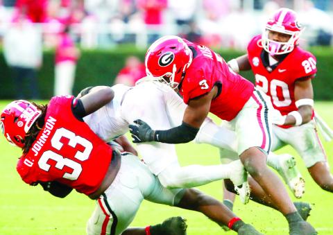 Georgia defensive lineman Quintavius Johnson (33) and linebacker CJ Allen (3) bring down an Ole Miss ball carrier. LANCE McCURLEY/Staff