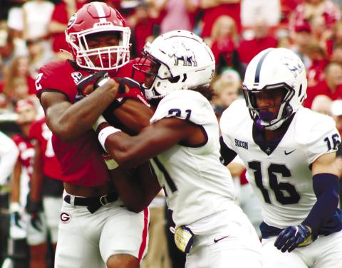 Bulldog running back Kendall Milton runs through a Samford defender as he tries to get more yards during the second half of last Saturday’s game in Sanford Stadium. BRENDAN KOERNER/Staff