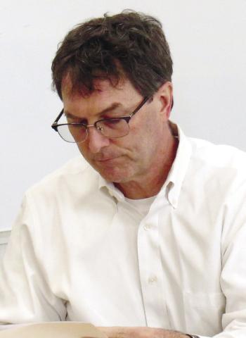 Greene County Board of Education Chairman Perry Lee studies a financial report while attending the LOA Board of Governors meeting Monday night.