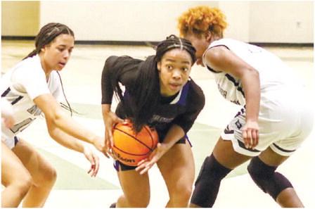Titans’ guard Jada Williams (22) splits two Wolfpack defenders in last weekend’s game in the Sandy Spiel Showcase at Grayson High School. LANCE McCURLEY/Staff