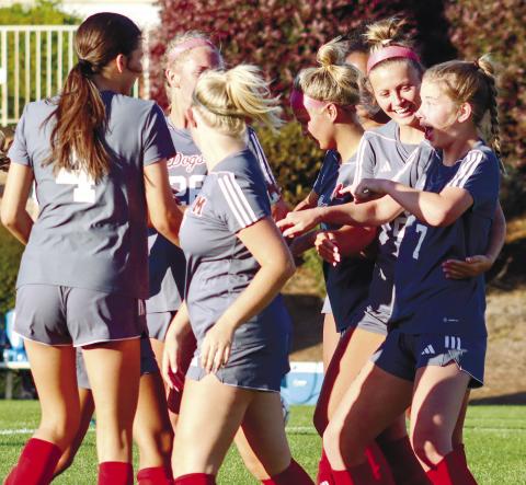 Several members of the Morgan County girls’ soccer team celebrate with Sidda Outlaw (7) after she scored a goal on Monday. LANCE McCURLEY/Staff