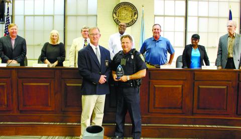 Madison Police Chief Bill Ashburn presents the Lifesaving Award to O_cer Mike Maxwell in front of the Madison City Council: (l-r) City Manager John Klimm, Betsy Wagenhauser, Ed Latham, Mayor Fred Perriman, Rick Blanton, Carrie Peters-Reid and Eric Joyce. T. MICHAEL STONE/Staff