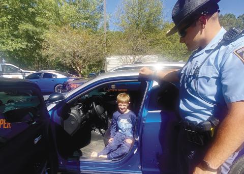 Christian Fuller, 8 years old, of Greensboro, checks out a few of the Georgia State Trooper vehicles. MAUREEN STRATTON/Staff
