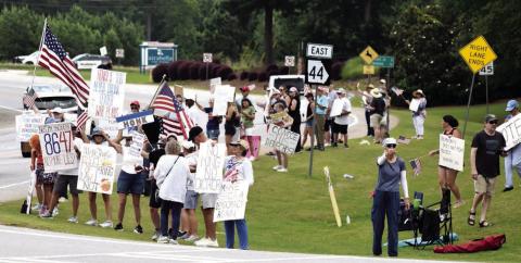 The No Kings rally held at the intersection of Lake Oconee Parkway and Linger Longer Road attracted people from six counties, many carrying signs expressing opposition to President Trump’s policies. T. MICHAEL STONE/Staff