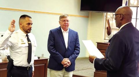Madison’s new police chief John McIlvaine (left) is sworn in by Mayor Fred Perriman while City Manager John Klimm looks on. T. MICHAEL STONE/Staff