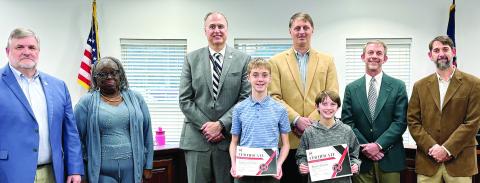 (L-R in front of board members): District spelling bee champion Emerson Williams and runner-up Beckett Cousins are recognized by the Board of Education. HANNAH BARRON/Staff