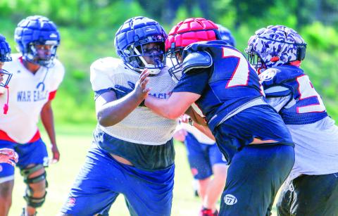 A Putnam County defensive lineman (72) goes up against an offensive lineman from Winder-Barrow during a padded camp held in Eatonton on July 17. LANCE McCURLEY/Staff