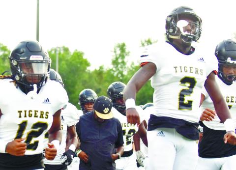 Greene County head coach Terrance Banks leads his team out onto the field before a scrimmage against Putnam County on Aug. 11. BRENDAN KOERNER/Staff