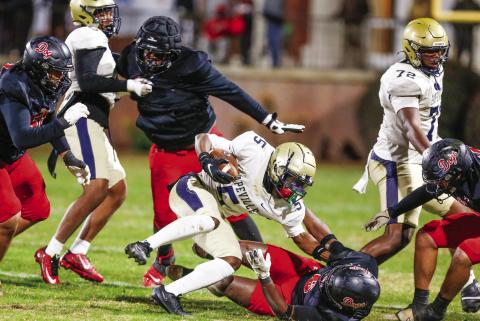 Hapeville Charter running back Traeven Jones (5) tries to avoid being brought down to the ground by a Morgan County defender. LANCE McCURLEY/Staff