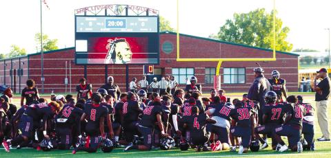 Baldwin players take a knee and listen to head coach Jesse Hicks during halftime of the Braves preseason scrimmage against Tattnall County. BRENDAN KOERNER/Staff