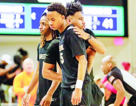 Braylen Hurt (5) walks off the court and is consoled by a member of the Greene County coaching staff after the Tigers lost to McIntosh County Academy on Friday in the Class A Division II semifinals. LANCE MCCURLEY/Staff