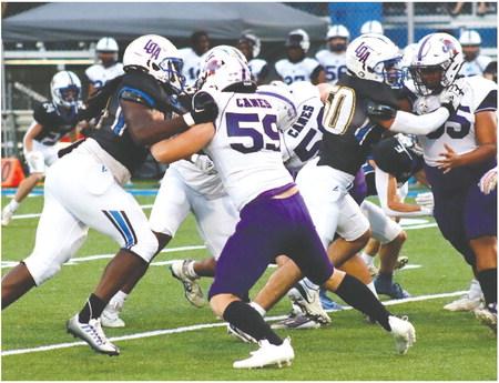 The Titans’ offensive line blocks the Hurricanes’ defensive front last Friday. BRENDAN KOERNER/Staff