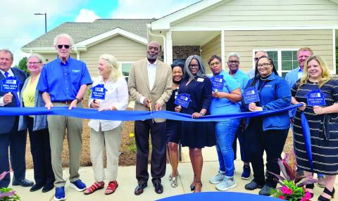 Madison Mayor Fred Perriman (center) cuts the ribbon at the Carmichael Commons grand opening, alongside city council members and representatives of several contributing companies. SKYLA MORRIS/Staff