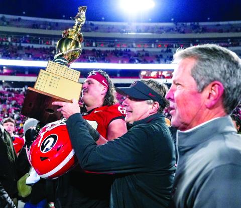 Georgia Gov. Brian Kemp (right) joins Georgia head coach Kirby Smart on the field on the field after the Bulldogs defeated Georgia Tech last season. FILE PHOTO