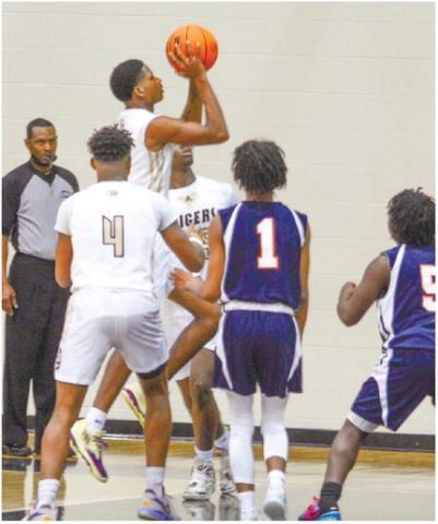 Sophomore guard Steve Miller (1) goes up for a layup over Taliaferro defenders in the Tigers’ season-opener last Tuesday night. BRENDAN KOERNER/Staff