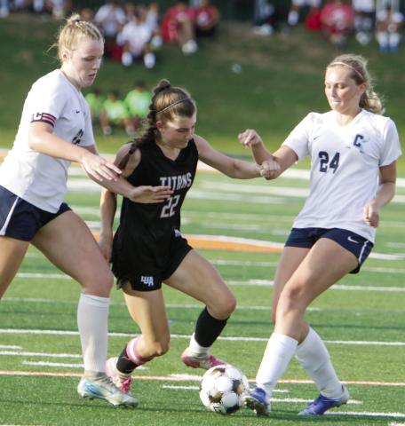 Top: LOA seniors Victoria Goubran (17) and Ellie Daniel (18) walk off the field together after the loss. Bottom: LOA senior Lauren Glass (22) tries to dribble the ball past defenders as she attempts to score. LANCE McCURLEY/Staff