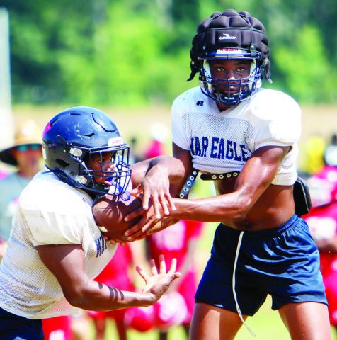 Putnam County senior quarterback Jamarion Robertson hands the ball off to sophomore running back Elijah Dunn during a scrimmage against Hawkinsville last week. (LANCE MCCURLEY/Staff)