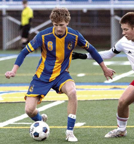 Lake Oconee Academy senior Garrett Griffin (6) dribbles the ball away from a GMC Prep defender during a home match on March 17. SKYLA MORRIS/Staff