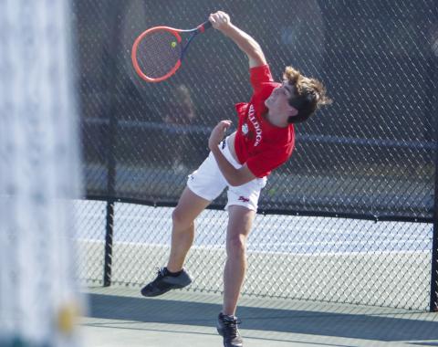 The Dogs’ No. 1 singles player, Aiden West, serves up an ace during a match against North Oconee on March 18. LANCE MCCURLEY/Staff