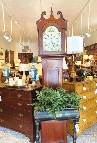 Two Early American chests, circa late 1700s to 1800s, flank an antique Grandfather clock upon entering Broad St. and Main.