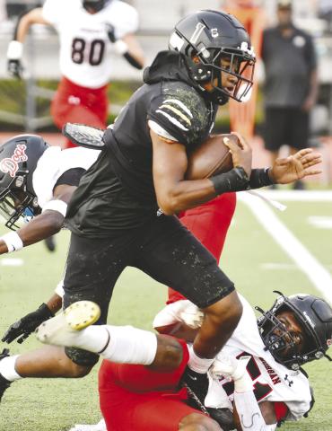 Tigers’ quarterback Steve Miller (1) runs over a Bulldog defender on his way to a 15-yard scramble. LANCE McCURLEY/Staff